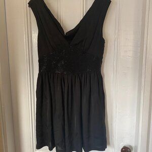Black babydoll mini dress. Beaded waist, Plunging neckline.